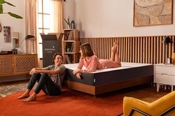 Man sitting on floor while woman lays on Cocoon mattress looking at each other